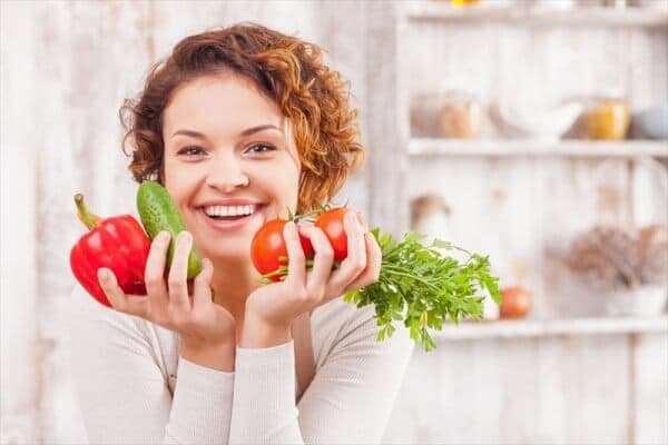 野菜を持って微笑む女性