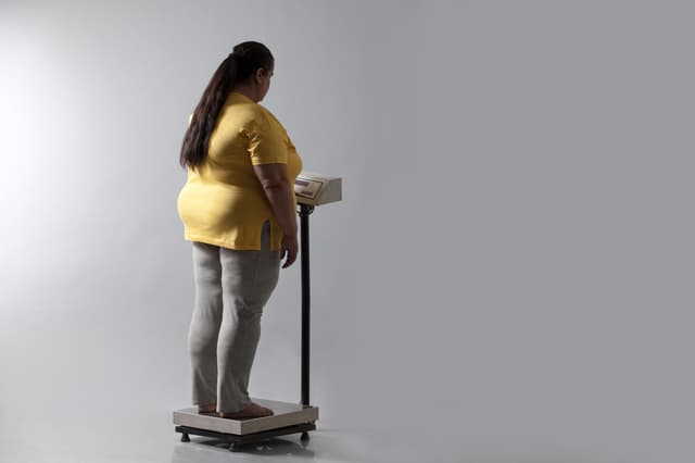 体重計に乗る豊満な女性