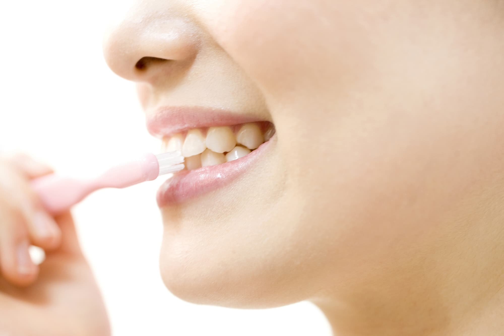 歯磨きをする女性の口元のアップ